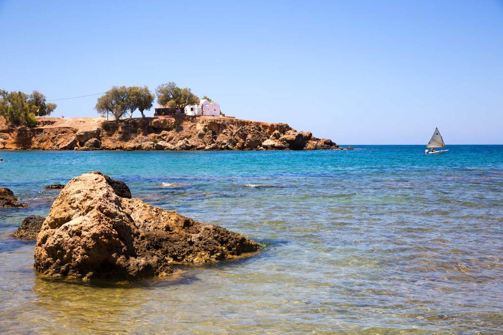 A man sails in Agii Apostoli Beach.