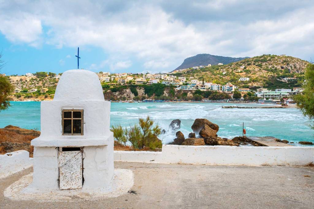 View of Almyrida Village and the organized beach next to a religious building.