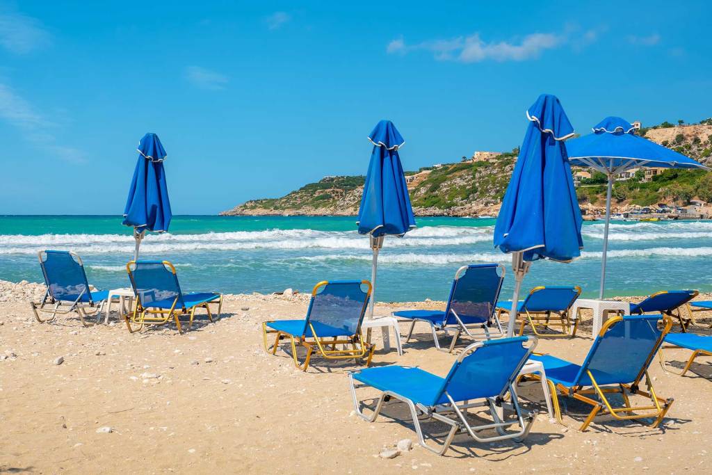 Sunbeds and umbrellas at the sandy Almyrida Beach.