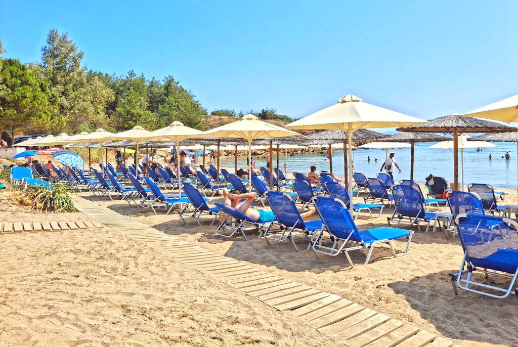 Sunbeds and umbrellas in the sandy Chrissi Akti Beach (Chania).