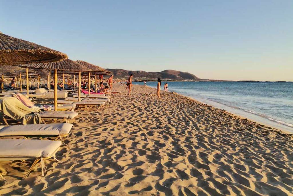 People sit on sunbeds at Falassarna Beach.