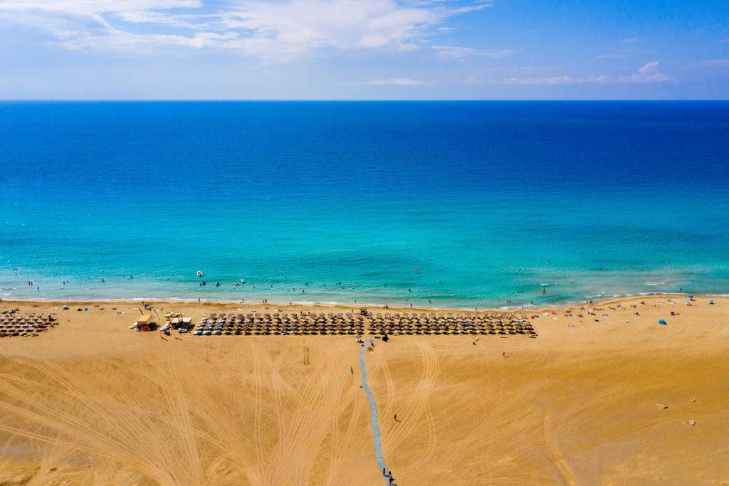 A long coast with sunbeds and umbrellas in Falassarna Beach.