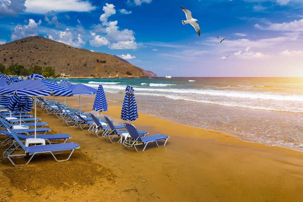 Sunbeds and umbrellas on the sandy beach of Georgioupolis.