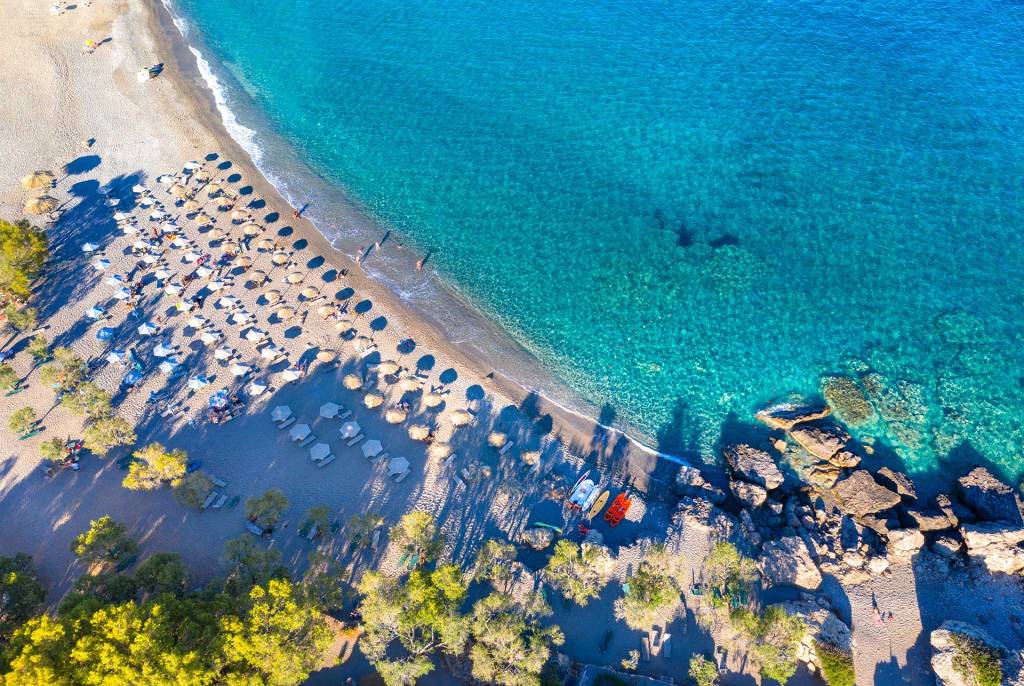 Sunbeds and umbrellas on the sandy coast of Gialiskari Beach.
