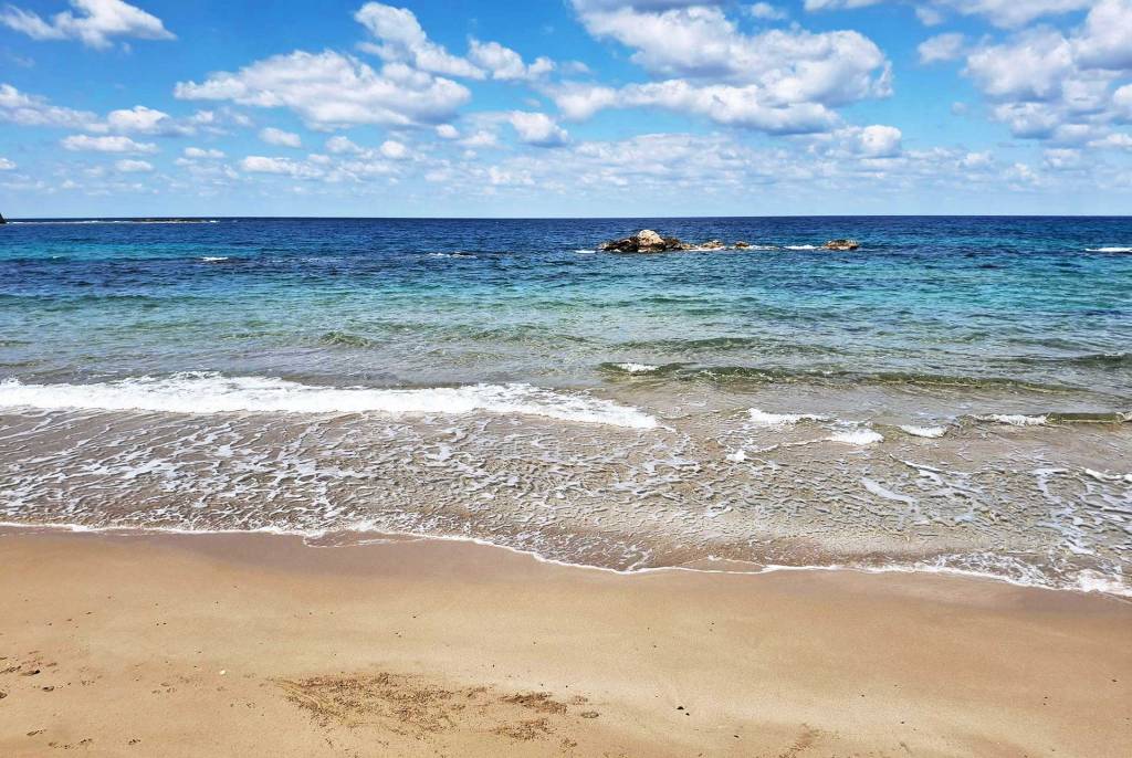 The sandy coast of Koum Kapi Beach.