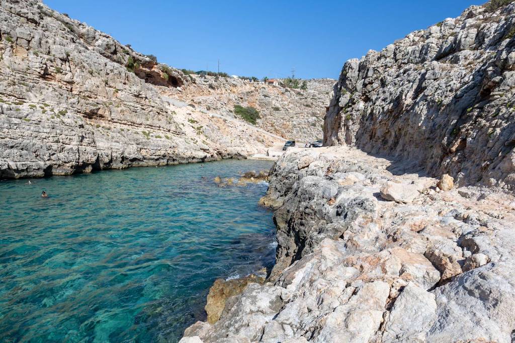 Koutalas Beach is between rocky cliffs.