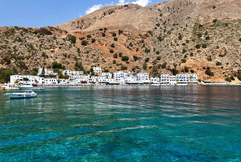 The picturesque seaside fishing village of Loutro, with white-washed houses and mountain views.