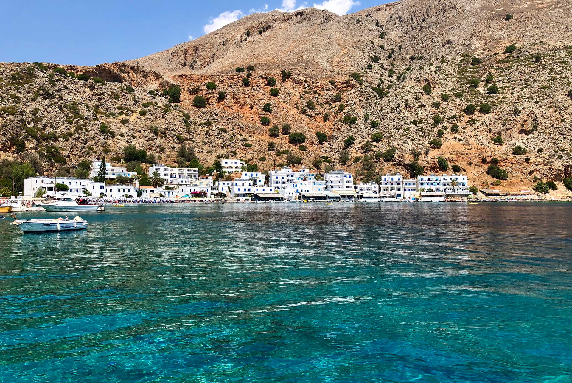 The picturesque seaside fishing village of Loutro, with white-washed houses and mountain views.
