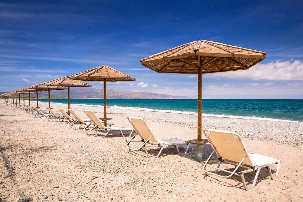 Sunbeds and umbrellas on the sandy Maleme Beach.