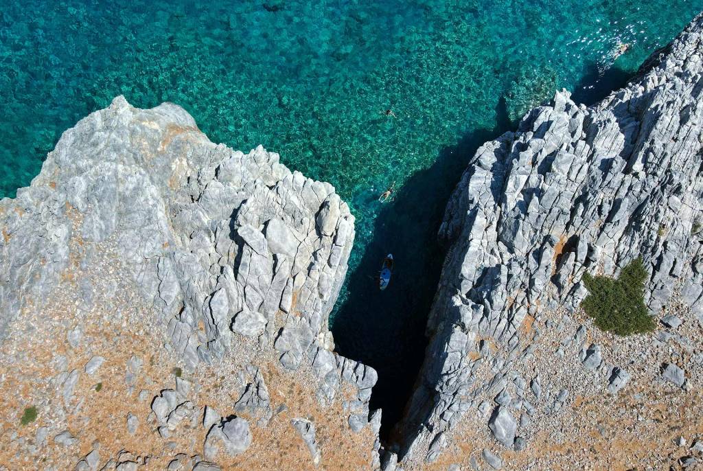 A small boat in the waters of Marmara Beach and the rocky landscape.