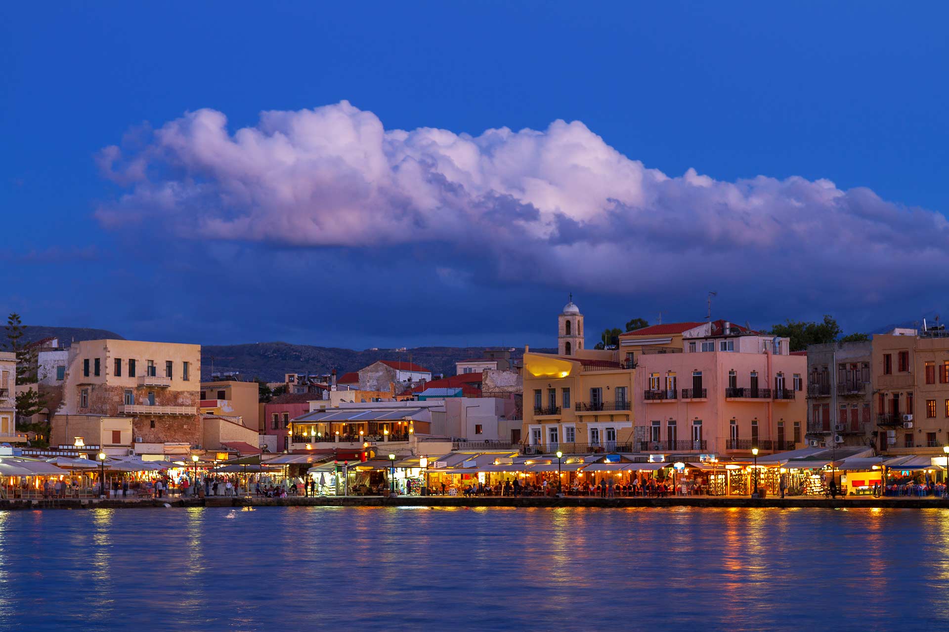 Night view of Chania Old Venetian Harbor, the picturesque houses, bars, and hotels.
