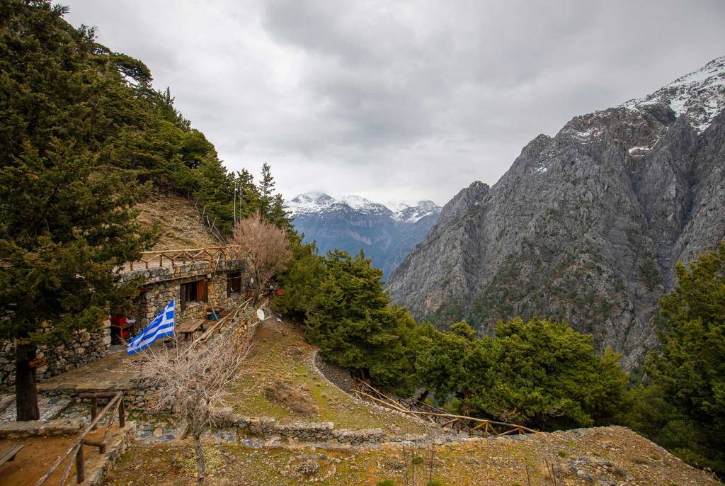The Greek Flag in Samaria Gorge, against the backdrop of the snow-capped mountains.