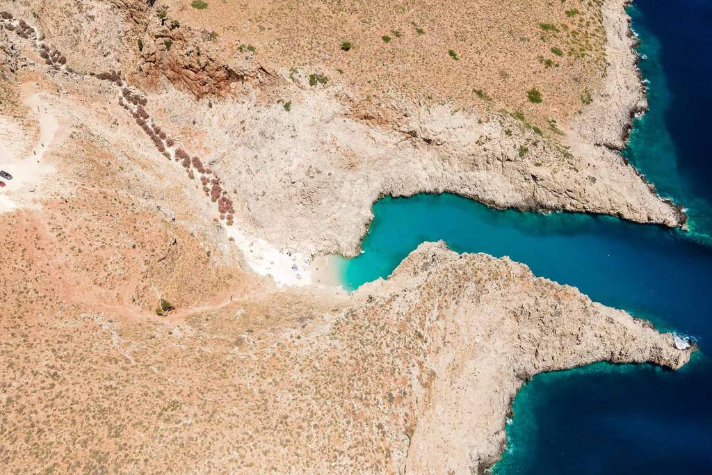 Aerial view of the rocky landscape and deep blue waters of Seitan Limania Beach.