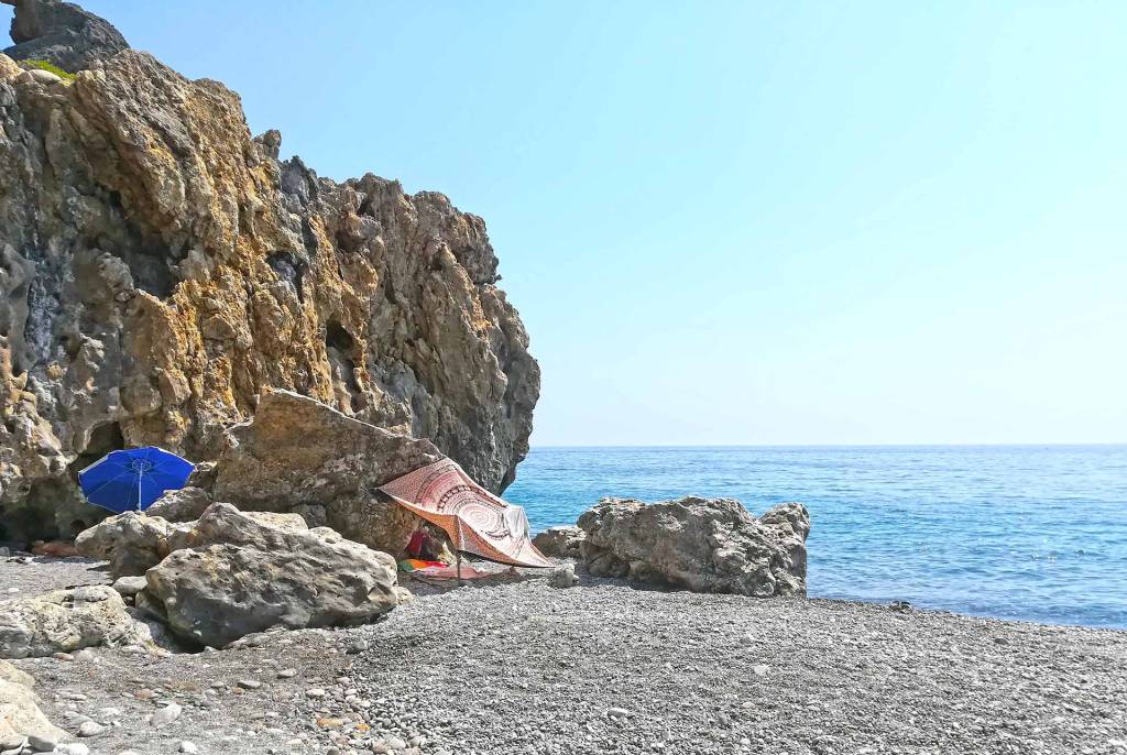 Umbrellas by the rocks of a small beach in Sougia.