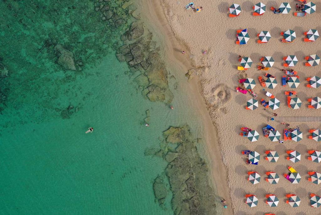 People swim in the waters of Stavros Beach.