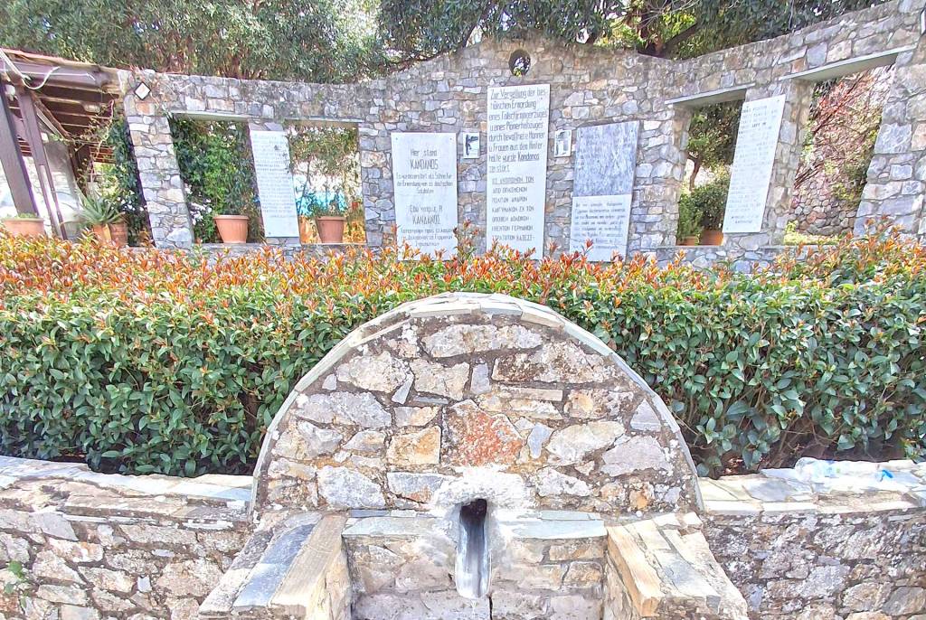 A stone-built source and a memorial wall in Kandanos.