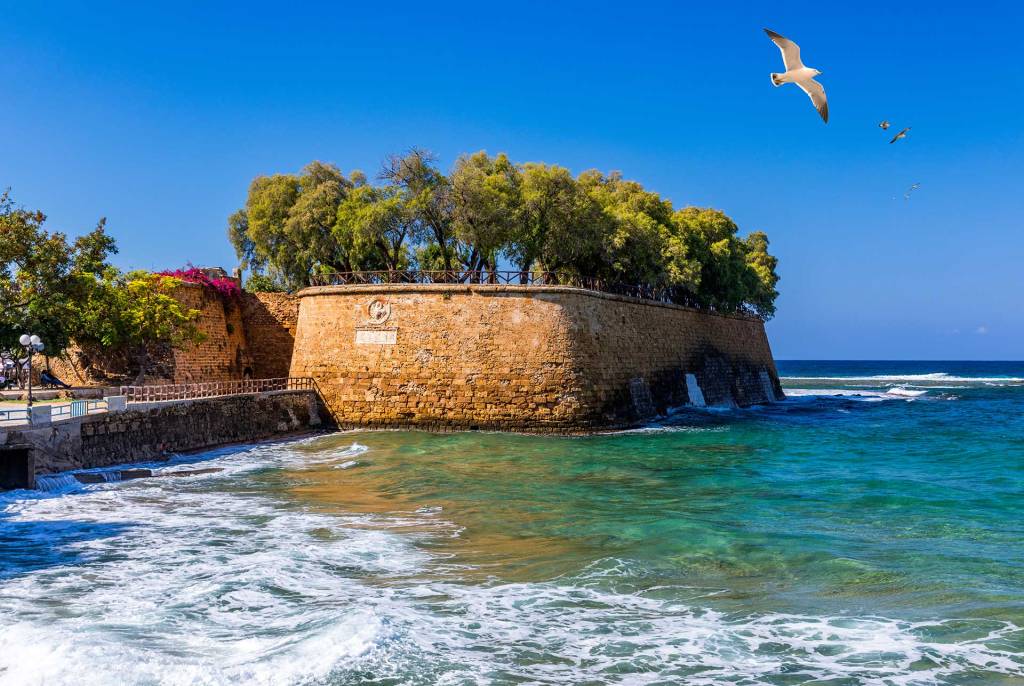 A flying seagull above the Sabbionara Rampart and the sea of Chania.