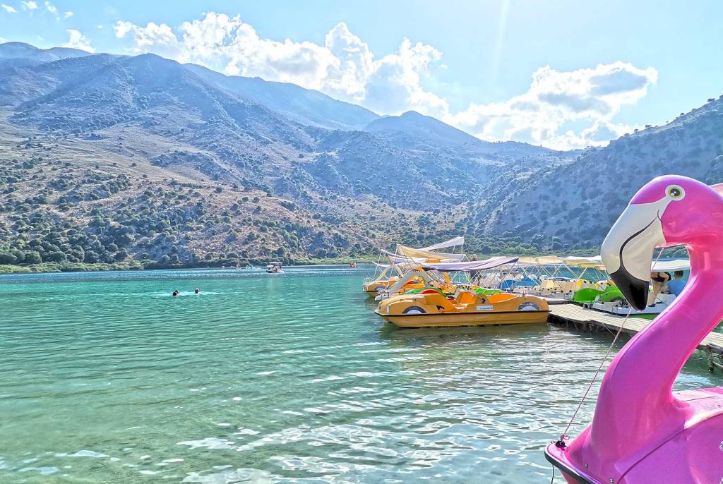 Pedal boats and people swim in Lake Kournas.