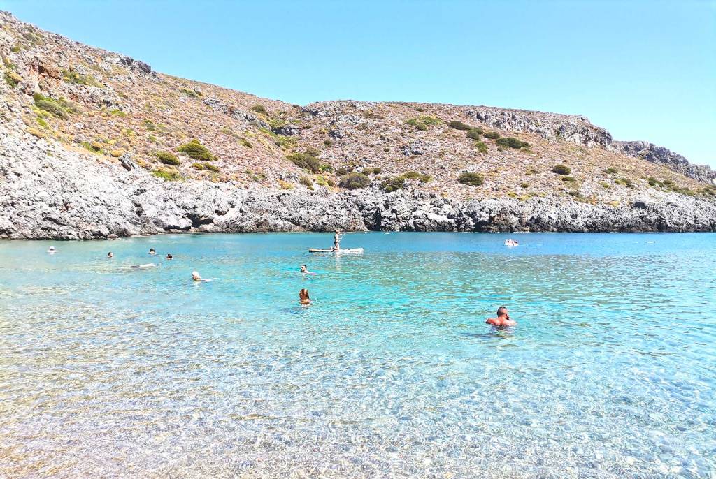 Tourists swimming and enjoying watersports in Melidoni Beach (Kythira).