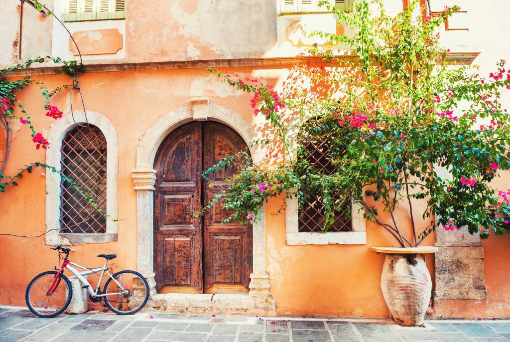A bicycle next to the beautiful wooden door of a building in Chania Old Town.