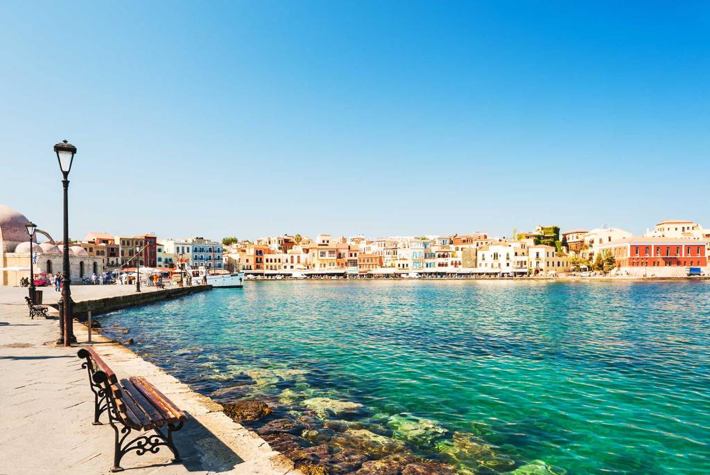 The picturesque Venetian Old Harbor of Chania with its colorful buildings, wooden benches, and the views of the sea.