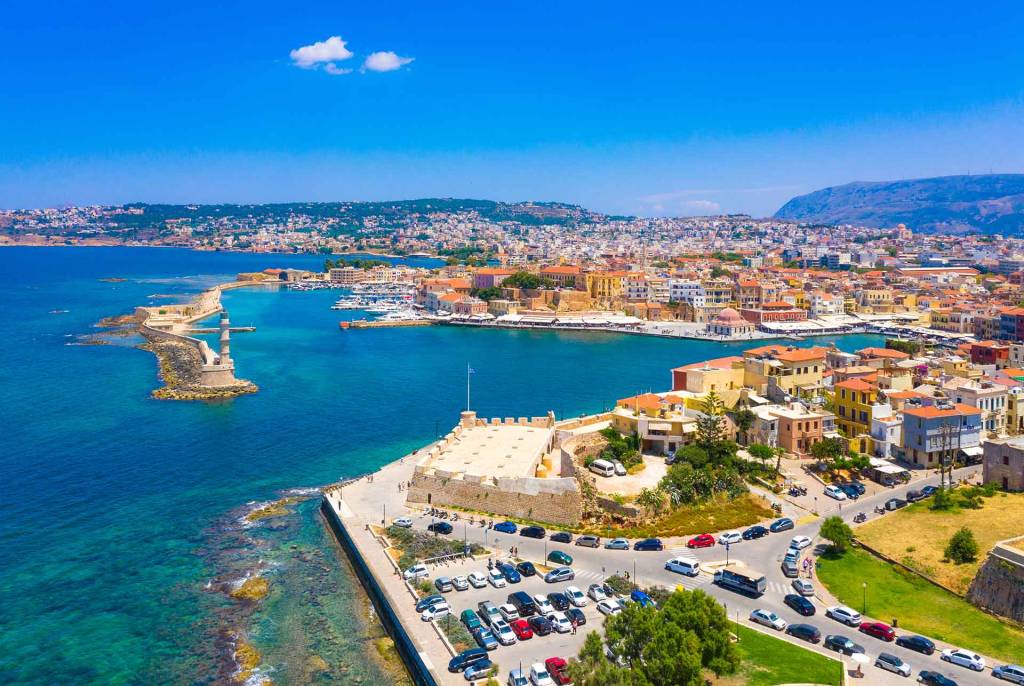 The lighthouse, colorful buildings, Firkas Fortress, and San Salvatore Bastion in Chania Old Town.