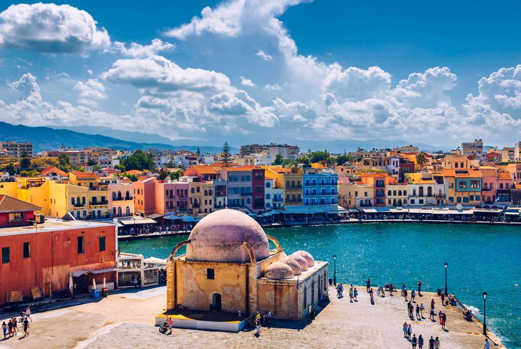 Tourists walking by Yali Tzami (Mosque) in Chania Old Town.