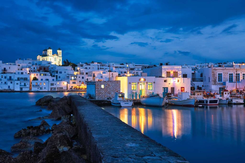 Night view of small boats and white buildings in Naoussa (Paros Island).