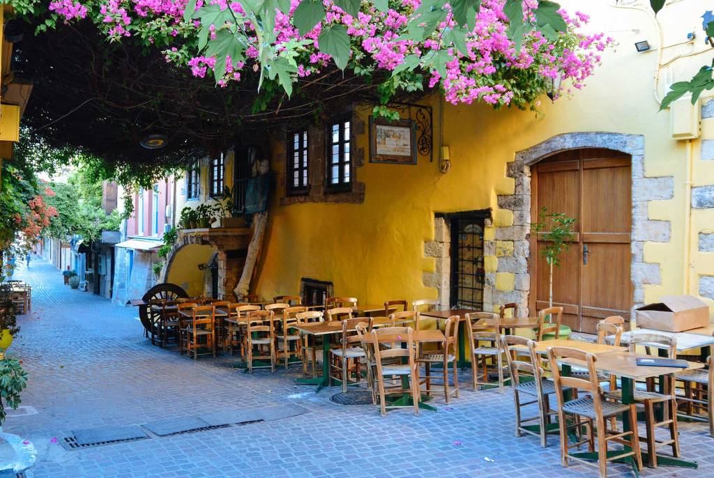 The wooden tables, chairs, and door of a picturesque restaurant in Daliani Street, close to Chania Old Town.