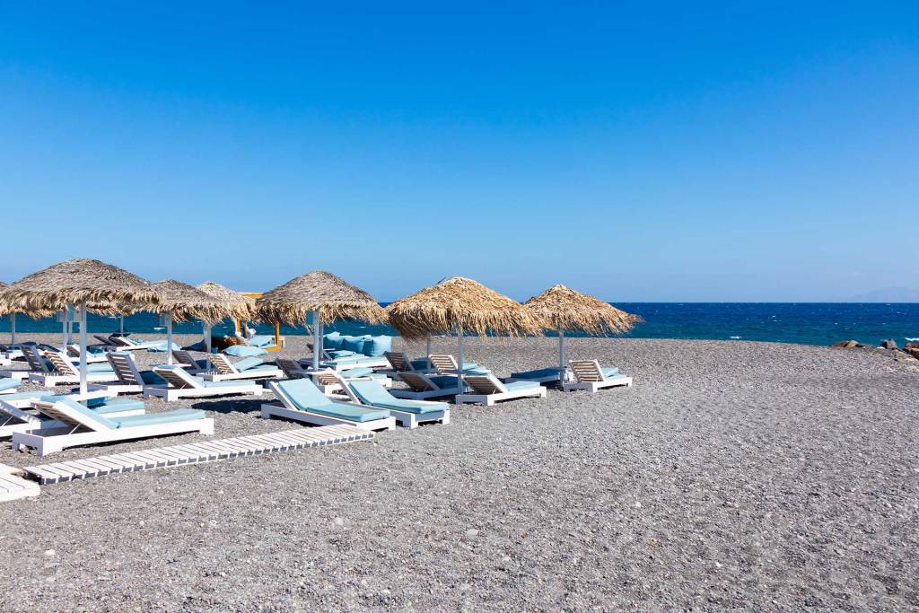 The sandy, organized Kamari Beach in Santorini.