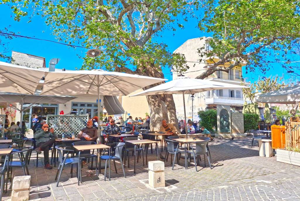 People sitting at small cafes in Splatzia Square.
