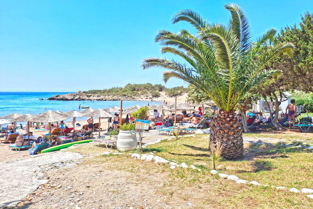 Sunbeds and umbrellas next to the lawn of the organized Grammeno Beach, next to Houmas.