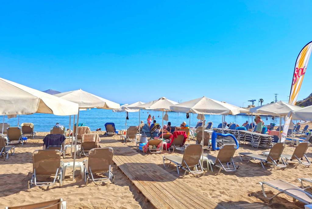 An organized beach with umbrellas and sunbeds in Kalyves Village.