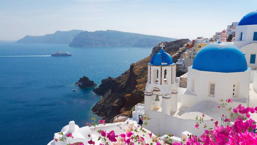 The island of Santorini, Caldera, and a ferry crossing the sea.