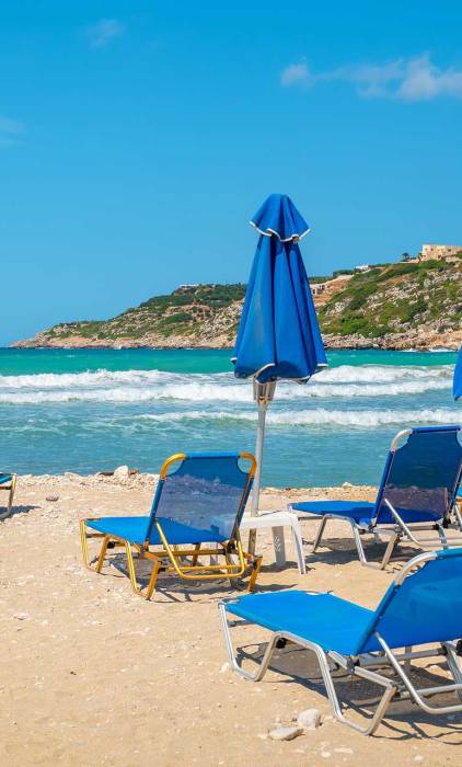Sunbeds and umbrellas at the sandy Almyrida Beach.