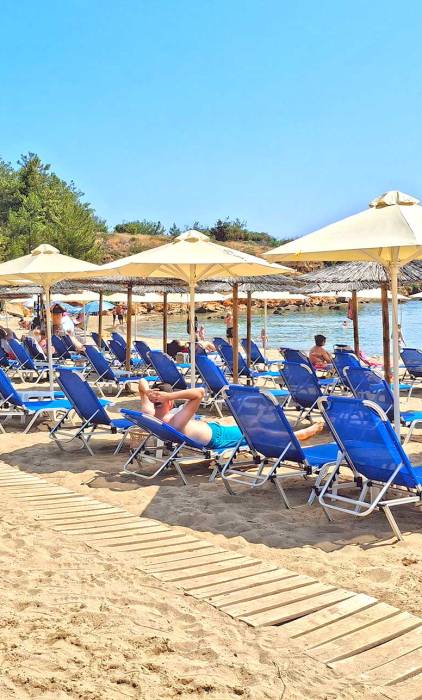 Sunbeds and umbrellas in the sandy Chrissi Akti Beach (Chania).