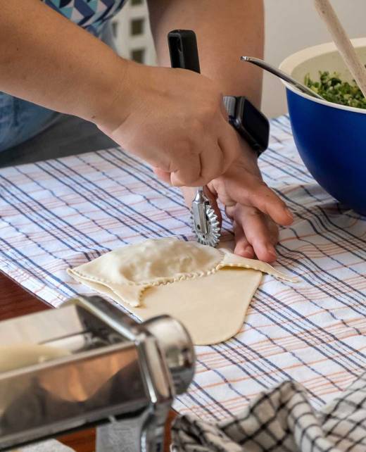 A woman is making dough for kalitsounia.