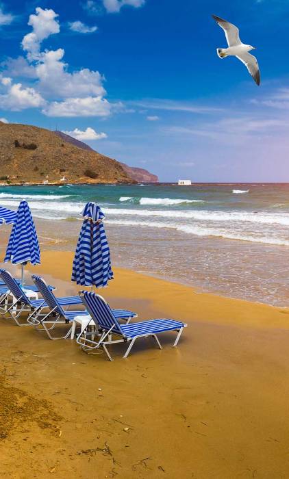 Sunbeds and umbrellas on the sandy beach of Georgioupolis.