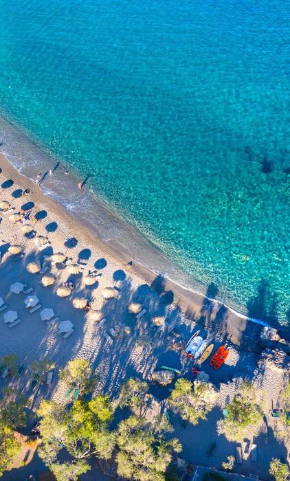 Sunbeds and umbrellas on the sandy coast of Gialiskari Beach.