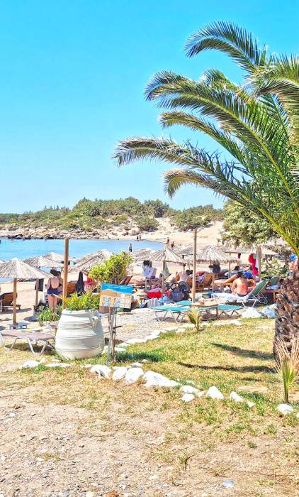 Sunbeds and umbrellas next to the lawn of the organized Grammeno Beach, next to Houmas.