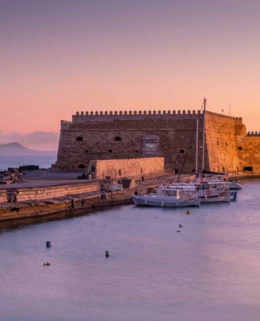 Sunset view of Heraklion Old Venetian Harbor and the fishing boats.