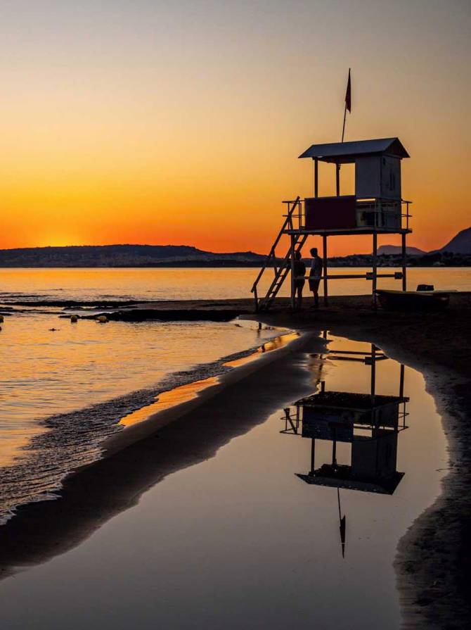 Sunset view of a lifeguard tower in Kato Stalos Beach.