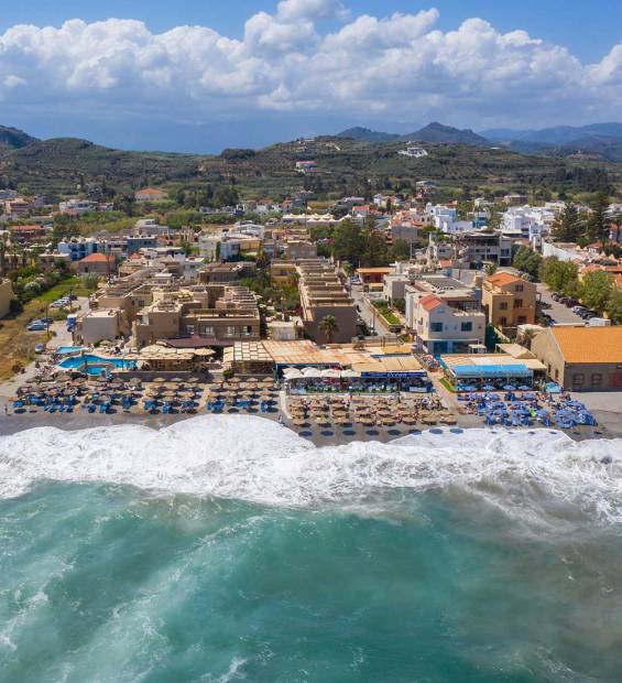 Sunbeds, umbrellas, and hotels in Platanias Beach.