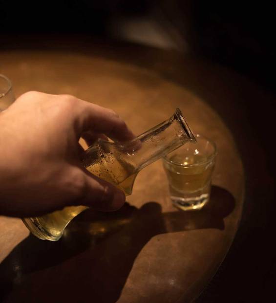 A man pouring raki into a glass.
