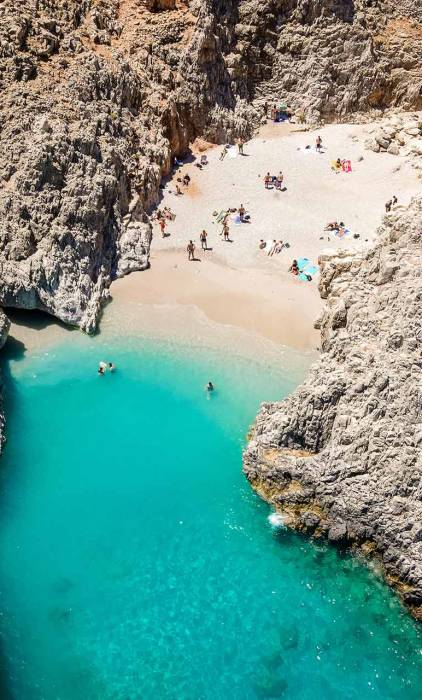People swimming and sunbathing in Seitan Limania Beach, Chania.