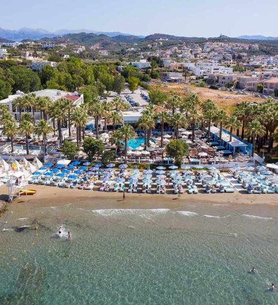 Umbrellas and sunbeds by the sea at local beach clubs in Agia Marina.